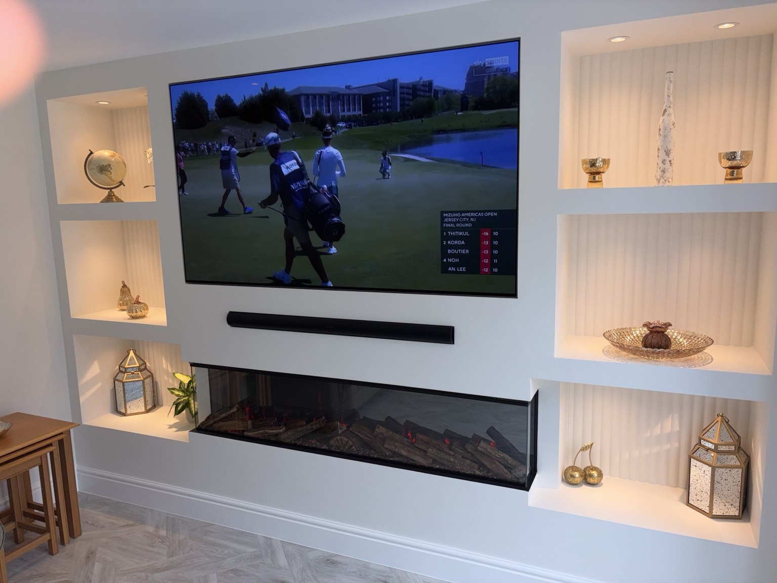 Custom fitted media wall with illuminated alcoves